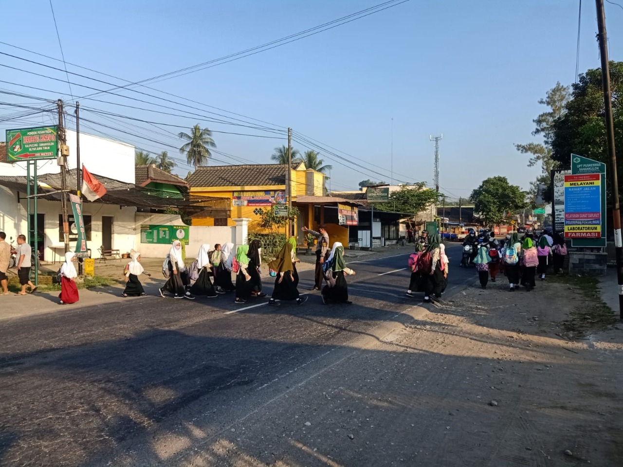 Polsek Sanankulon - Pos pagi pengaturan arus lalulitas merupakan tugas rutin pagi hari yang dilaksanakan oleh anggota Polsek Sannakulon. Apalagi saat sekarang sudah memasuki hari sekolah bagi siswa dan pelajar yang berangkat menuntut ilmu. Personel menyeberangkan siswa siswi yang berangkat sekolah di depan Puskesmas Sanankulon. Rabu (27/7/22). Aiptu Sunardi mengatakan bahwa pagi hari sebagian anak anak berangkat sekolah dengan berjalan kaki, oleh sebab itu kami seberangkan karena arus lalulintas pagi hari relatif ramai. ucapnya. Lebih lanjut Aiptu Sunardi menambahkan bahwa pengaturan arus lalulintas bertujuan untuk memberikan rasa aman dan nyaman, terutama untuk menjaga keselamatan pengguna jalan yang lain baik yang menggunakan kendaraan Roda 4 atau Roda 2 serta anak-anak yang berangkat sekolah. Hal ini juga merupakan wujud pelayanan kepada masyarakat utamanya anak sekolah maupun masyarakat yang mengawali aktifitasnya saat pagi. Selain itu juga sebagai upaya untuk mendekatkan diri pada masyarakat, sehingga masyarakat merasa aman dalam aktivitas sehari-hari karena ada petugas di sekitarnya. “Terima kasih pak Polisi, saya dan teman-teman tidak takut lagi untuk menyeberang jalan karena sudah ada Pak Polisi setiap hari". ucap salah satu siswa Sekolah Dasar yang berangkat menuju sekolah.